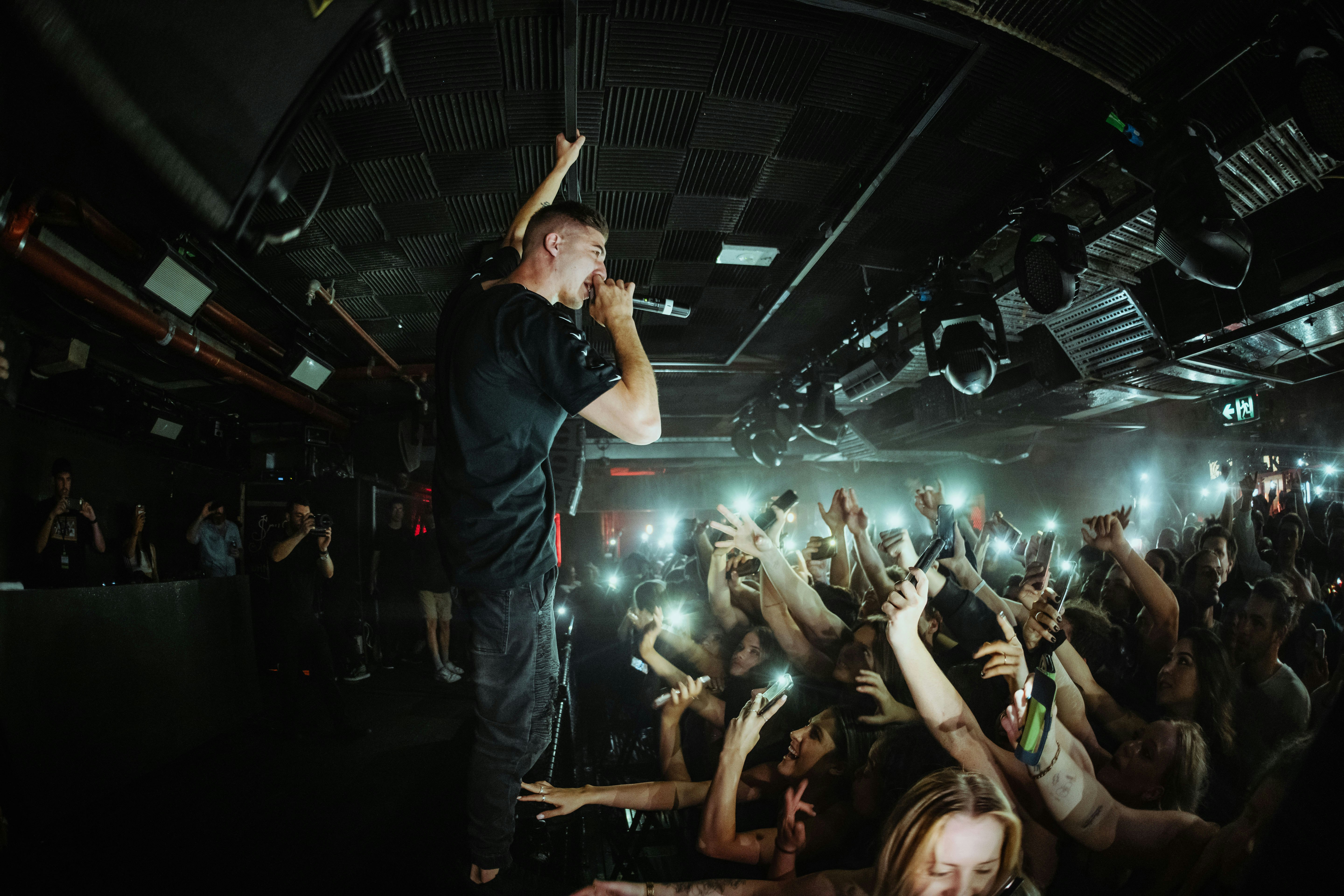 man in black t-shirt raising his hands